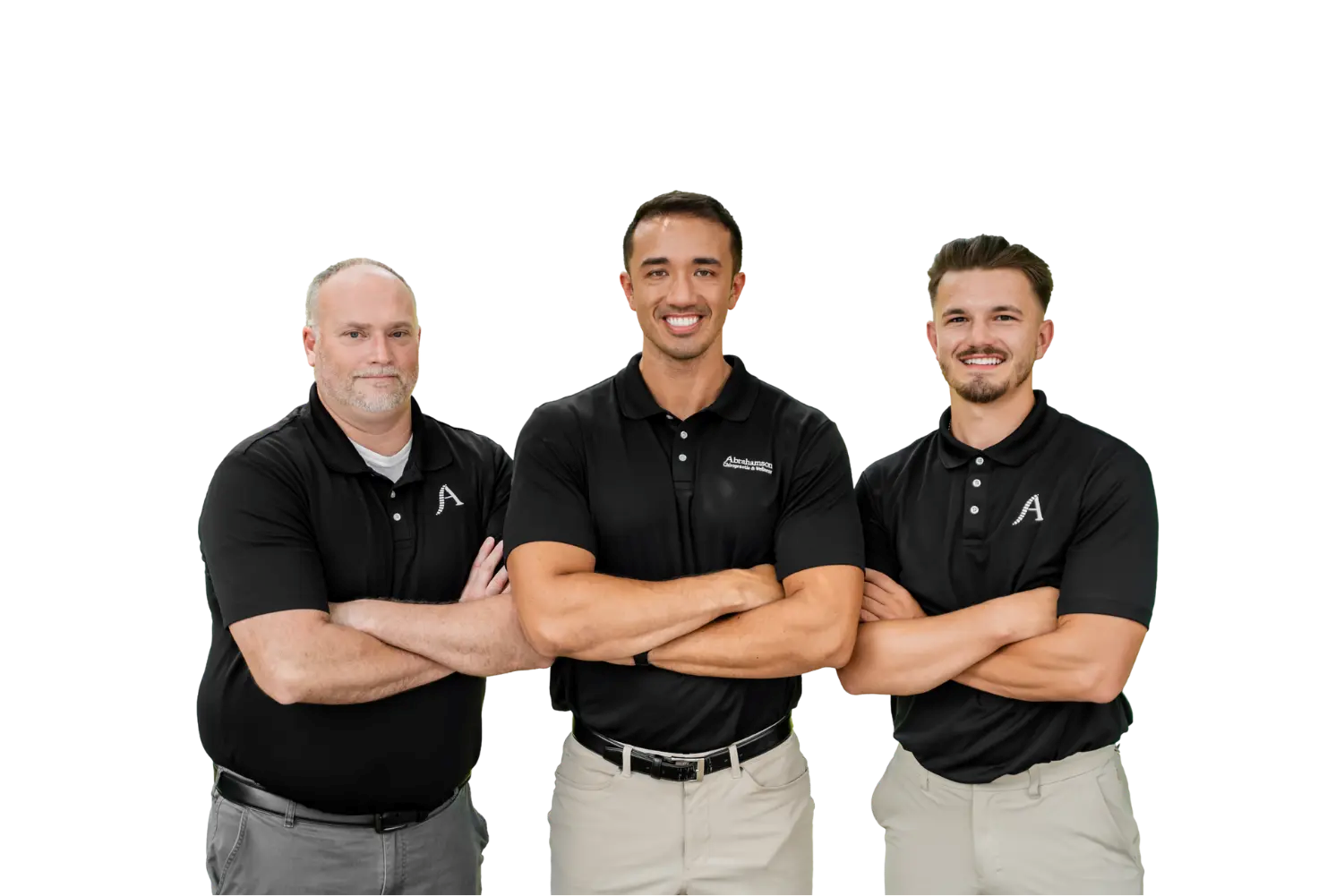 Three men stand side-by-side with arms crossed, all wearing black polo shirts and light pants, against a plain white background—presenting a professional team ready to serve as your chiropractor Hendersonville TN specialists.